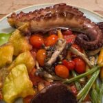 Polvo à Murciana: tentáculos de polvo grelhados à moda de Múrcia, servidos com batatas douradas, tomate grelhado e cebola caramelizada. Um clássico espanhol com intensidade e frescor mediterrâneo